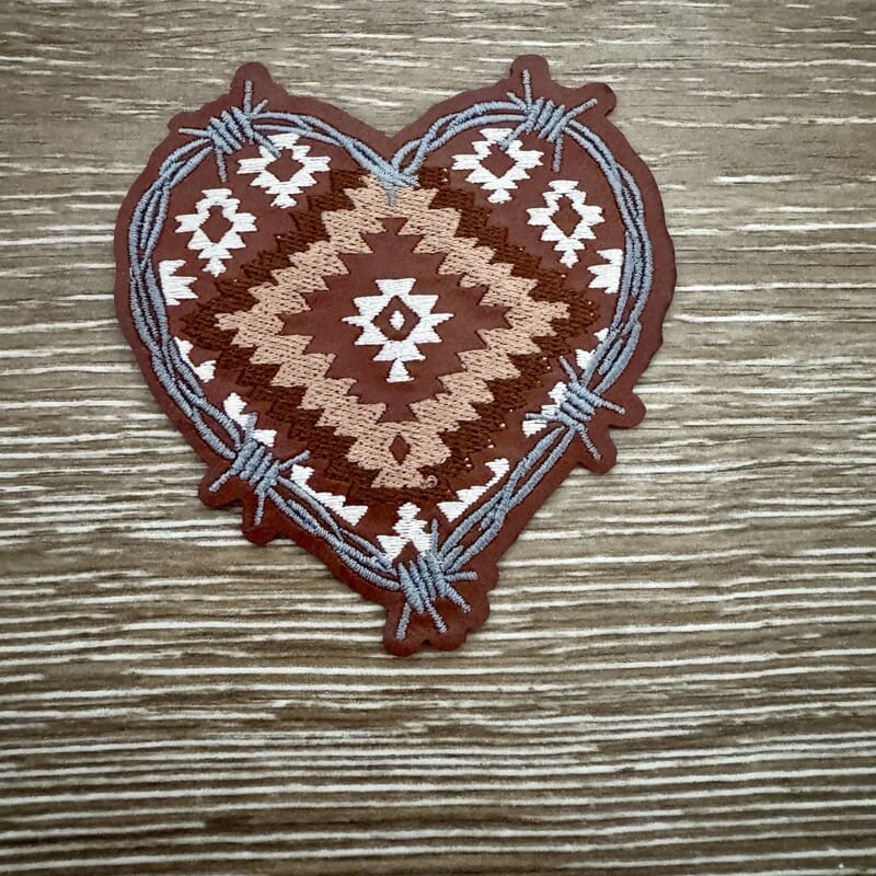 Aztec barbed wire heart iron-on patch with tan Aztec stitching on brown heart wrapped in gray wire