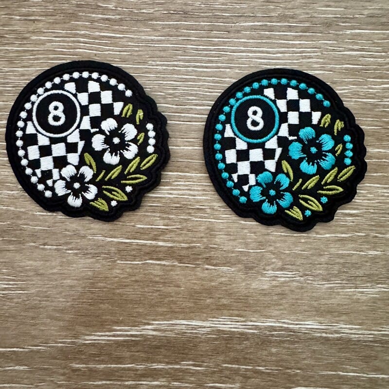 Checkered 8-ball iron-on patch with teal and white floral accents