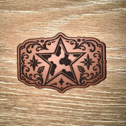 Cow print western star laser-engraved leather-look iron-on patch in a floral buckle-style frame by On A Whim Hats