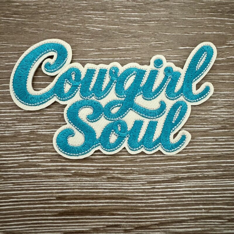 Cowgirl Soul chenille iron-on patch in fuzzy teal cursive script with cream outline