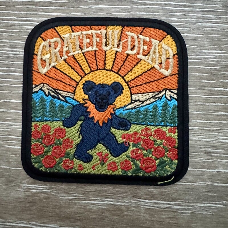 Dancing bear silhouette iron-on patch in rose garden sunset scene