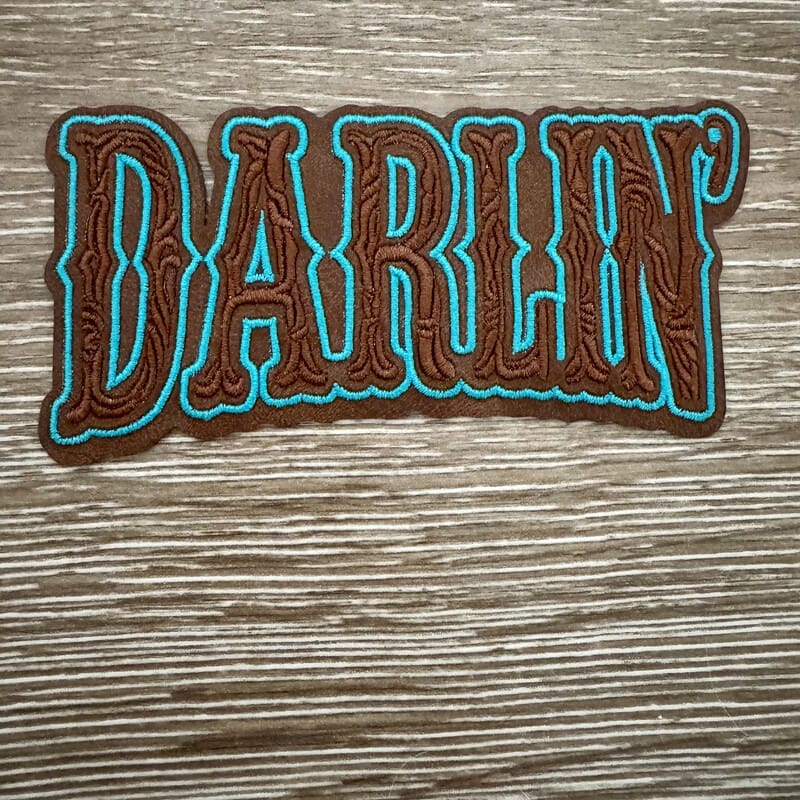 Darlin' western letters iron-on patch with saloon-style brown lettering and turquoise outline