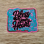 Bless Your Heart western glitter iron-on patch with black script, pink glitter base and teal floral embroidery
