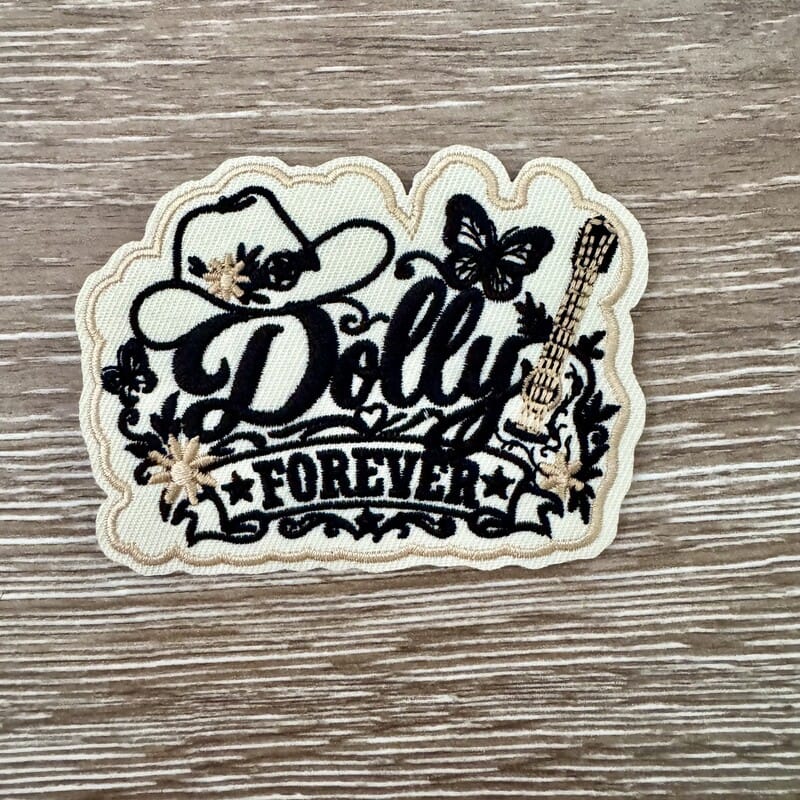 Black and cream Dolly Classic Country Queen Forever iron-on patch with script, cowboy hat, butterflies and guitar