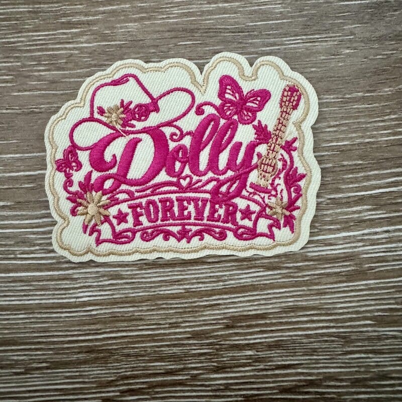 Scalloped cream Dolly Country Queen Forever iron-on patch with pink cursive, cowboy hat, butterflies and guitar
