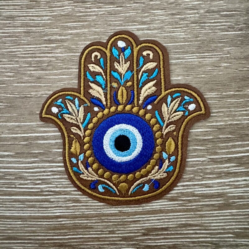 Hamsa hand evil eye boho iron-on patch in brown and gold with floral design and blue eye center by On A Whim Hats