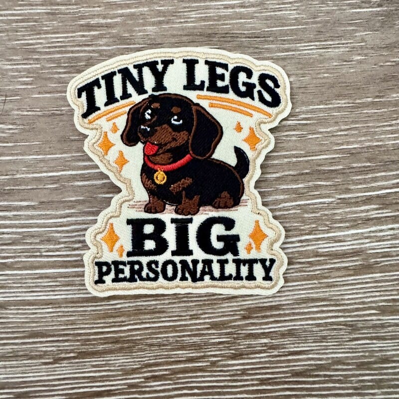 Tiny Legs Big Personality dachshund iron-on patch with bold lettering and orange sparkle accents by On A Whim Hats