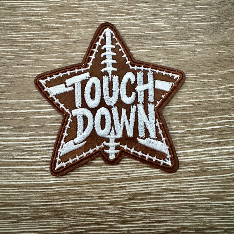 Star-shaped Touchdown football leather iron-on patch with bold lettering and football stitching detail by On A Whim Hats