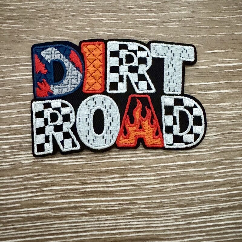Dirt Road iron-on patch with chunky letters in checkered flag, flame, denim and bandana prints