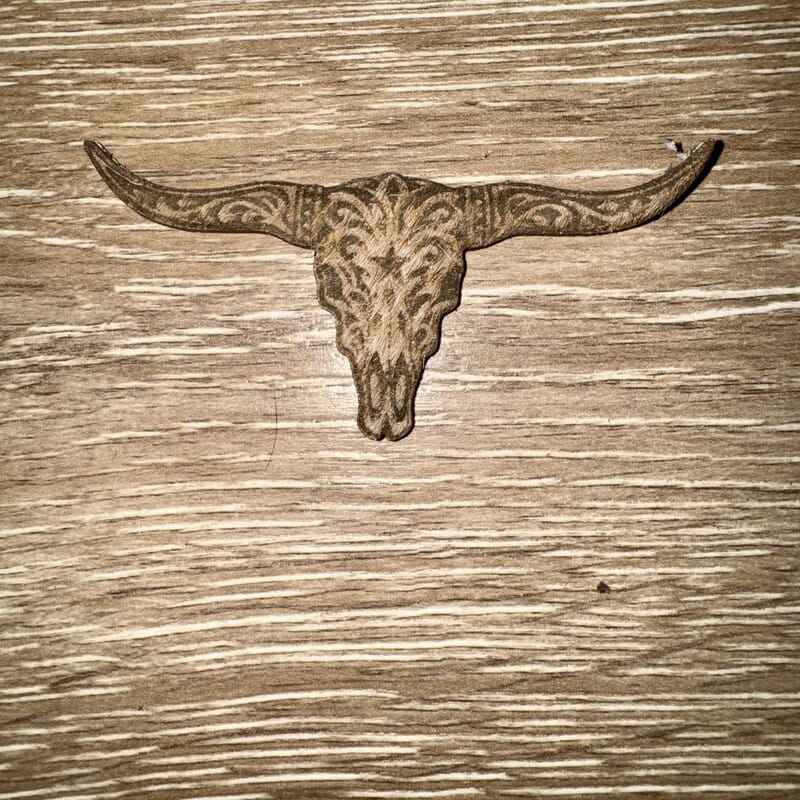 Engraved longhorn skull scrollwork genuine cowhide iron-on patch with wide horns on a natural tan base by On A Whim Hats