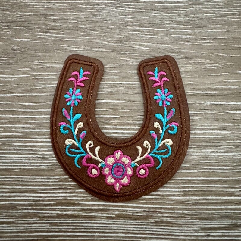 Folk floral horseshoe iron-on patch with colorful flowers and vines in pink, teal and orange