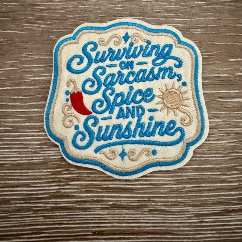 Sarcasm Spice and Sunshine embroidered iron-on patch with teal script, chili pepper and sun on cream