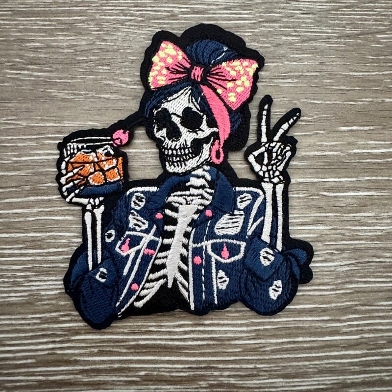 Sassy Skeleton Bow iron-on patch with skeleton girl in denim jacket, leopard bow and hoop earrings