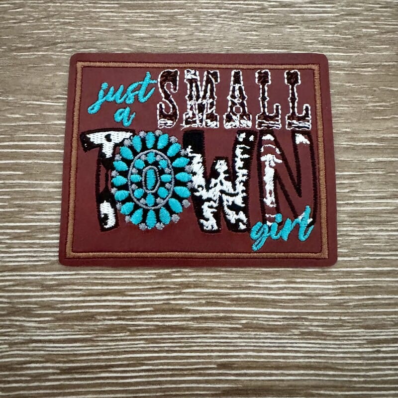 Small Town Girl leather iron-on patch with cowhide print lettering and turquoise squash blossom concho