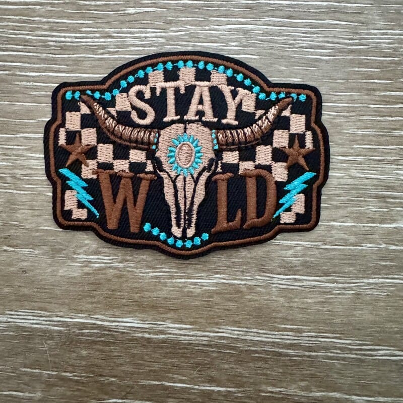 Stay Wild longhorn skull iron-on patch on checkered background