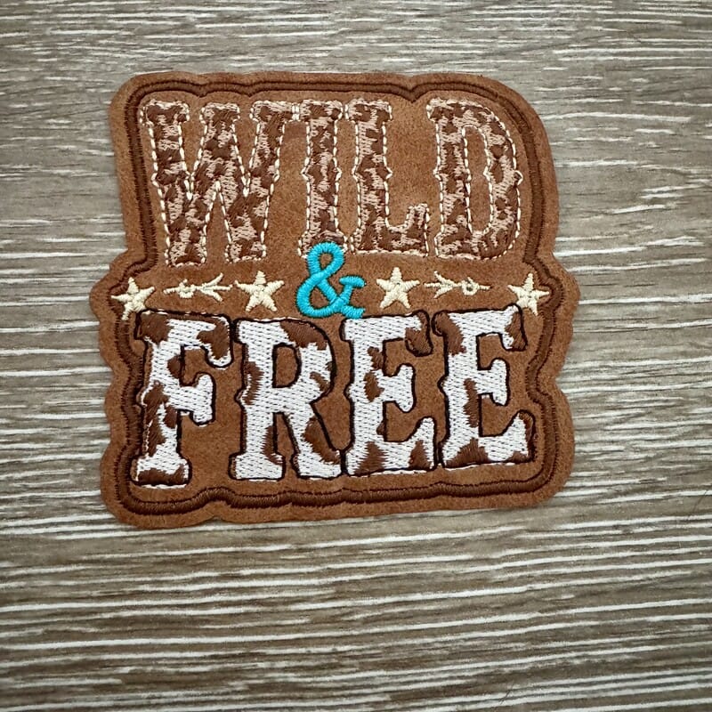 Wild and Free iron-on patch with leopard and cowhide print lettering and western stars on brown