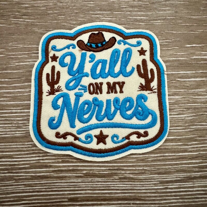 Y'all On My Nerves embroidered iron-on patch with teal script, cowboy hat, cactus and stars on cream