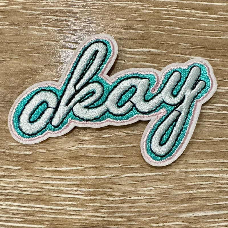 On A Whim Hats Okay Embroidered Iron-On Patch